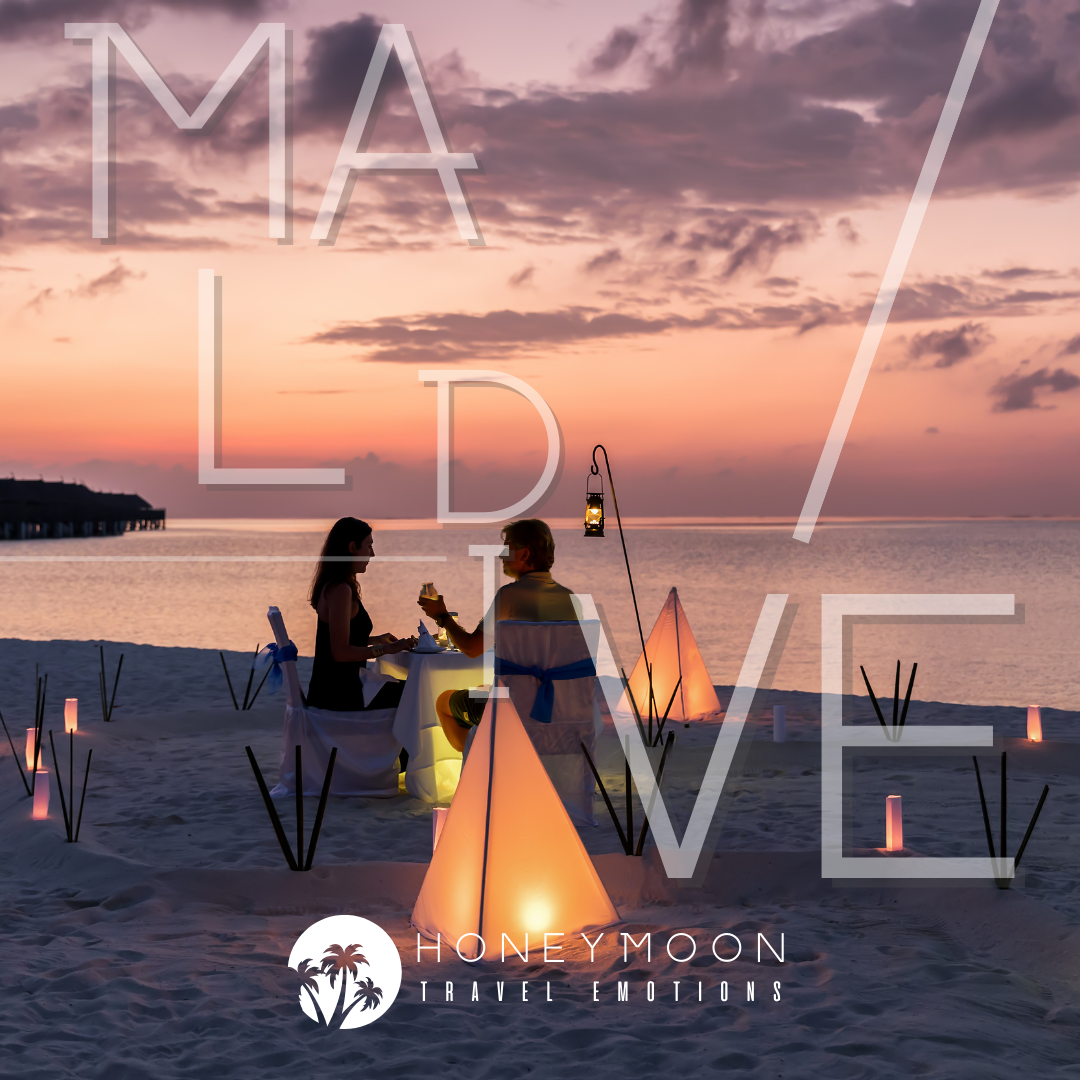 Cena romantica a lume di candela sulla spiaggia al tramonto durante un viaggio di nozze alle Maldive.
